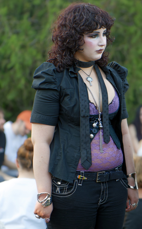 11 - Person dressed in gothic fashion, featuring a black puff-sleeve top over a purple lace corset